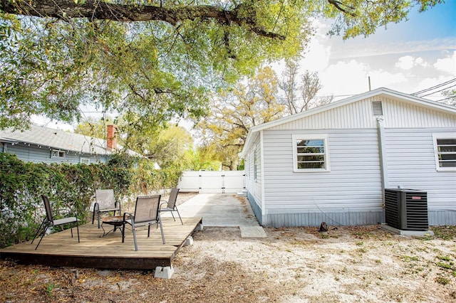 rear view of property with cooling unit, a gate, fence, and a deck