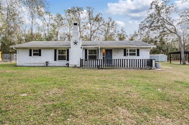 single story home with a front yard, brick siding, a chimney, and a storage unit