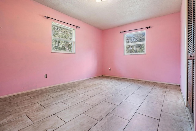 empty room with a textured ceiling and a healthy amount of sunlight