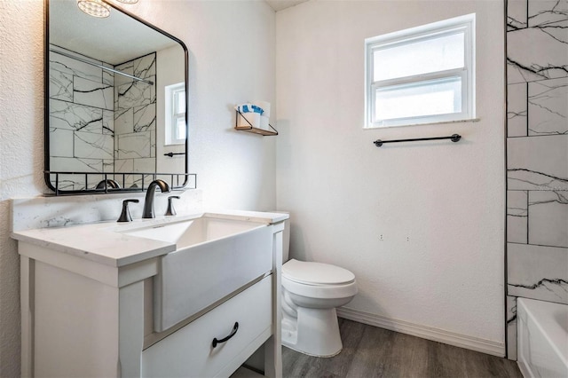 bathroom featuring wood finished floors, vanity, toilet, and baseboards