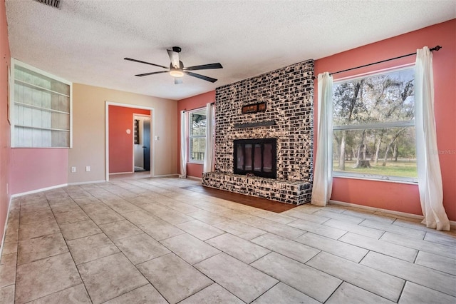 unfurnished living room featuring a ceiling fan, tile patterned flooring, a fireplace, and a textured ceiling