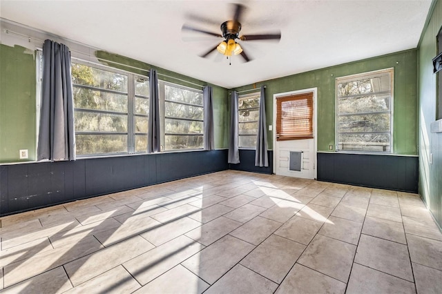 tiled empty room with a ceiling fan