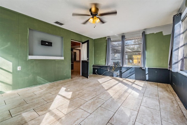 spare room featuring a healthy amount of sunlight, ceiling fan, and visible vents