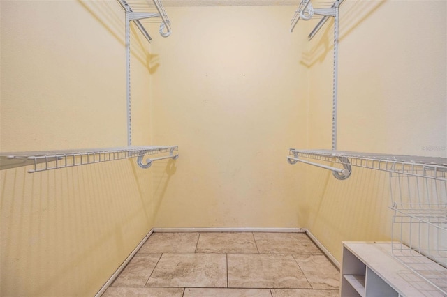 spacious closet with light tile patterned floors