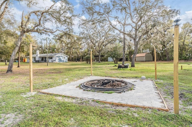 view of yard featuring an outbuilding, a fire pit, and a shed