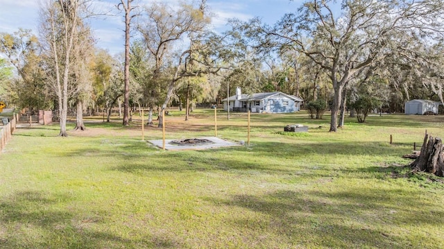 view of yard with an outdoor fire pit and fence