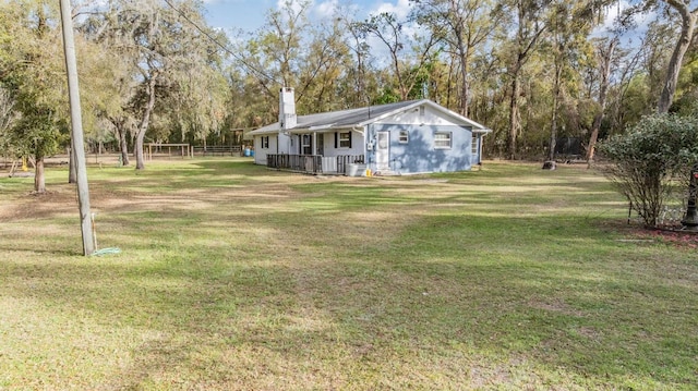 view of yard featuring covered porch and fence