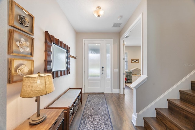 foyer featuring dark wood-style floors, visible vents, stairway, and baseboards