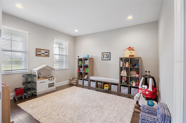 recreation room featuring plenty of natural light, baseboards, dark wood-style flooring, and recessed lighting