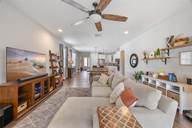 living room featuring visible vents, arched walkways, a ceiling fan, wood finished floors, and recessed lighting