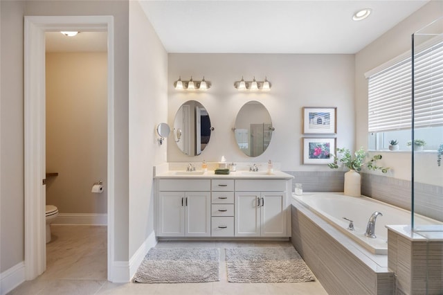 bathroom featuring a garden tub, tile patterned flooring, toilet, a sink, and double vanity