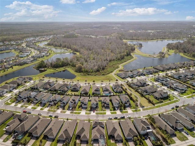 bird's eye view featuring a wooded view, a water view, and a residential view