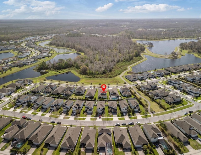 bird's eye view featuring a wooded view, a water view, and a residential view