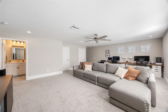 living room featuring a ceiling fan, visible vents, baseboards, light carpet, and recessed lighting