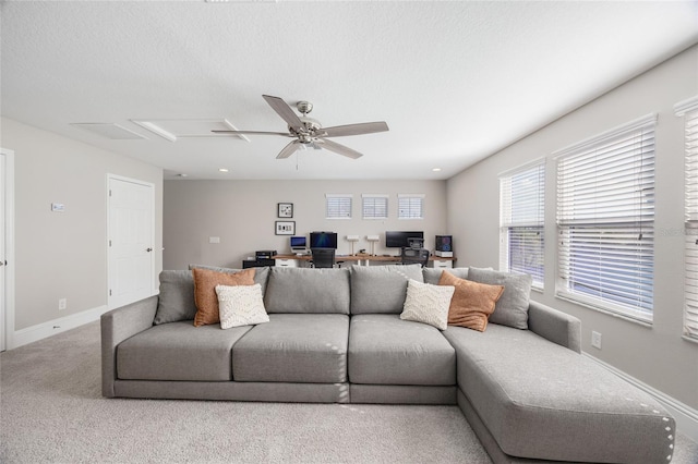 carpeted living area with a textured ceiling, ceiling fan, and baseboards