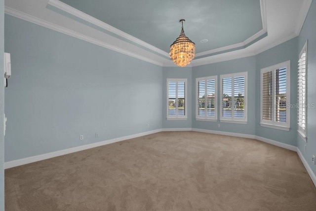 unfurnished room featuring a tray ceiling, crown molding, an inviting chandelier, light carpet, and baseboards