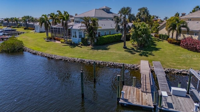 dock area with a water view, glass enclosure, and a yard