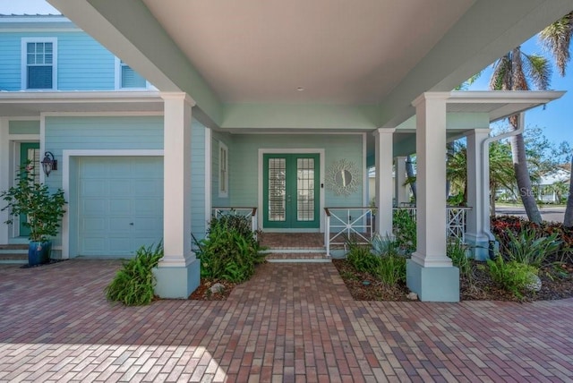 property entrance featuring a porch, french doors, and an attached garage