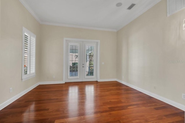 empty room with french doors, visible vents, crown molding, and wood finished floors