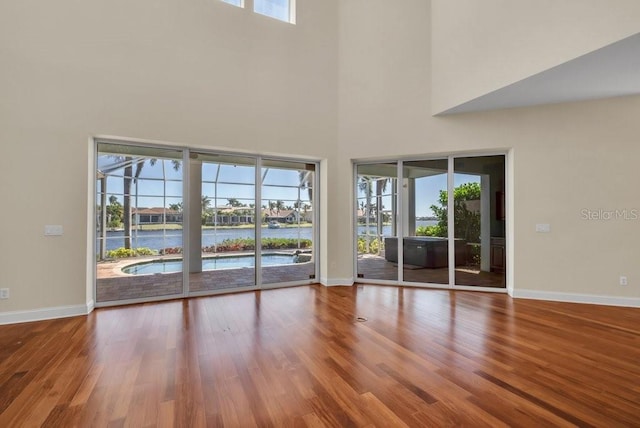 unfurnished living room featuring wood finished floors and baseboards