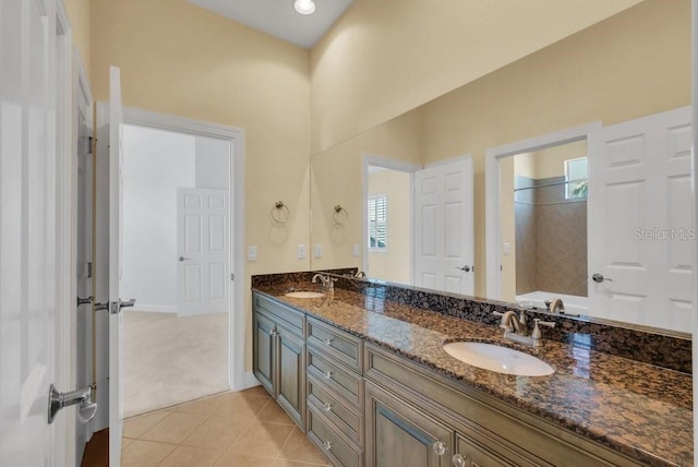 bathroom with a washtub, double vanity, a sink, and tile patterned floors