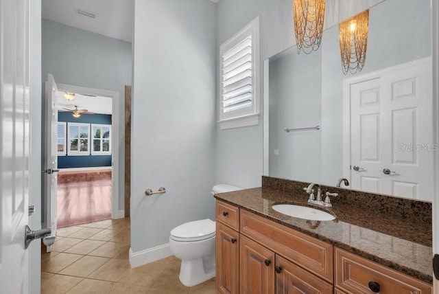 bathroom featuring baseboards, visible vents, toilet, tile patterned floors, and vanity