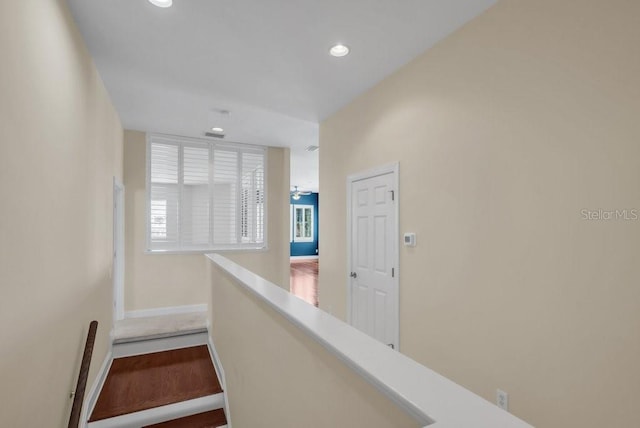 hall featuring recessed lighting, baseboards, and an upstairs landing