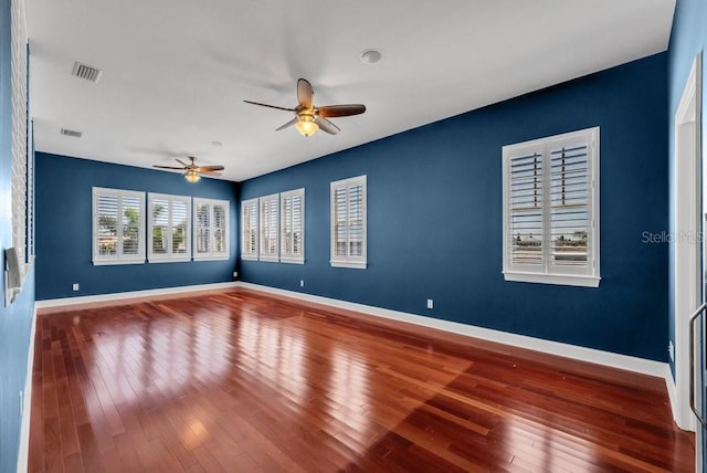 spare room with visible vents, baseboards, and hardwood / wood-style flooring