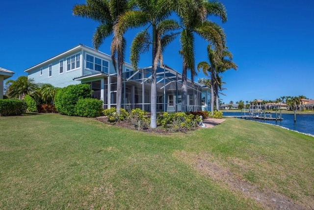 view of yard with glass enclosure and a water view