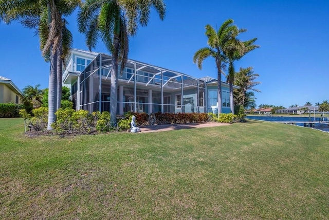 back of house with a lanai and a yard