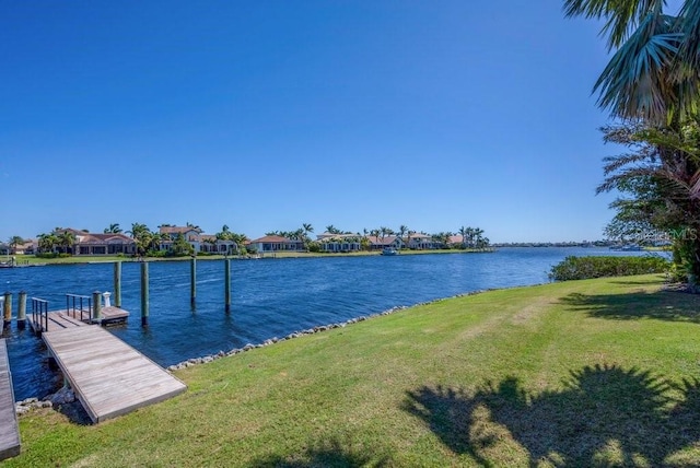 view of dock with a water view and a yard