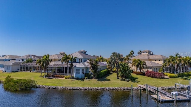 rear view of property featuring a yard, a water view, and a residential view