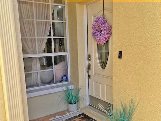 doorway to property featuring stucco siding