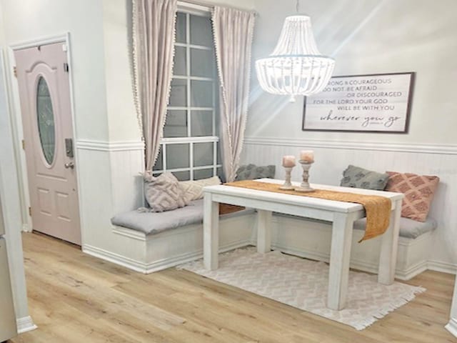 sitting room with a notable chandelier, wood finished floors, and a wainscoted wall