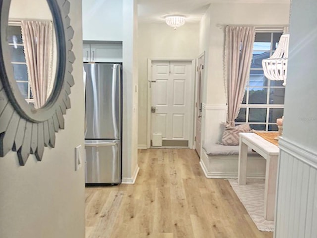 interior space with light wood finished floors and wainscoting