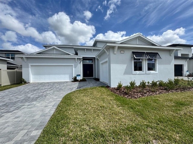 single story home with an attached garage, fence, decorative driveway, stucco siding, and a front lawn