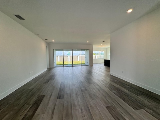 unfurnished living room featuring dark wood-type flooring, recessed lighting, visible vents, and baseboards