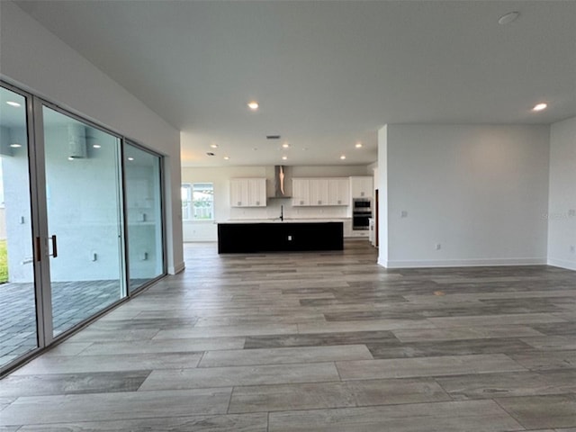 unfurnished living room featuring light wood-style flooring, baseboards, and recessed lighting