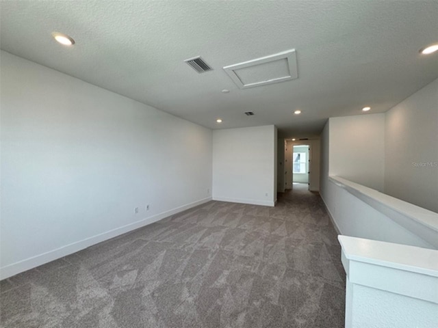 unfurnished room with carpet floors, recessed lighting, visible vents, attic access, and baseboards