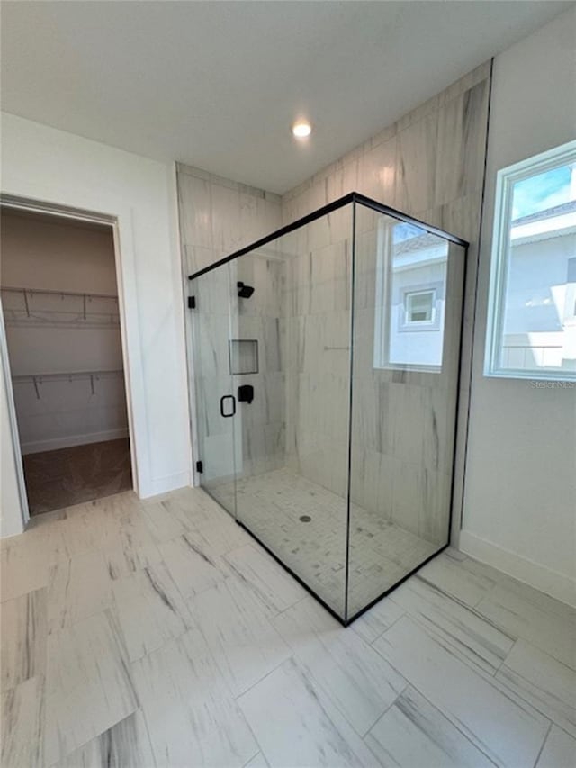 full bath featuring a shower stall, a spacious closet, baseboards, and recessed lighting