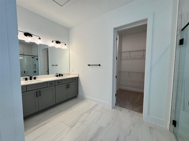 bathroom with a sink, a spacious closet, double vanity, and a shower stall