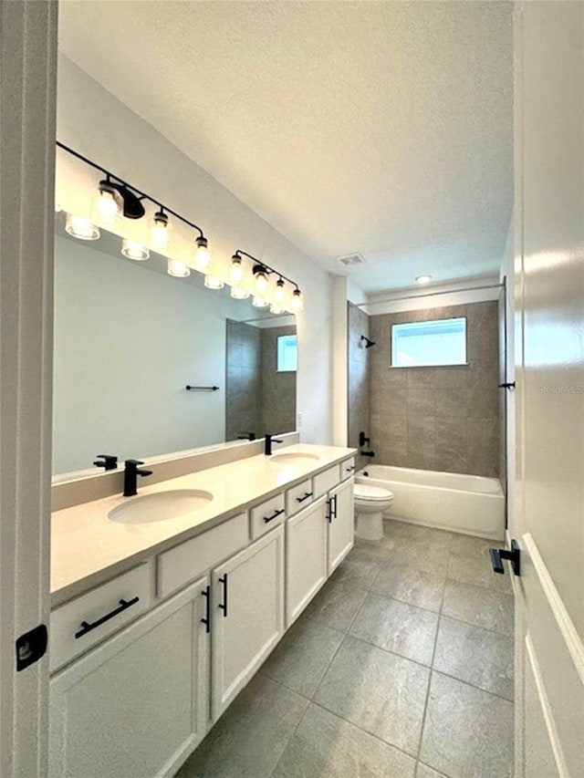 bathroom with double vanity, toilet, bathtub / shower combination, a textured ceiling, and a sink