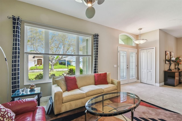 living area with light tile patterned flooring, french doors, and baseboards