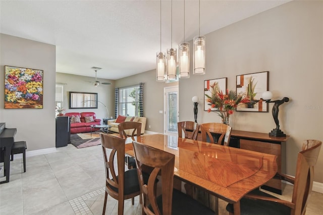 dining room with light tile patterned flooring, a ceiling fan, and baseboards