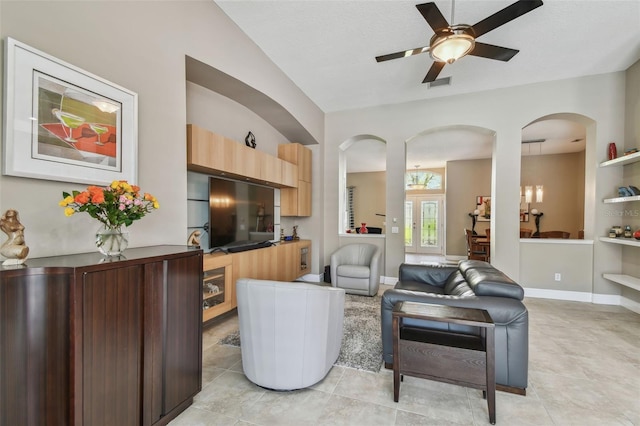 living room featuring light tile patterned floors, visible vents, baseboards, and a ceiling fan