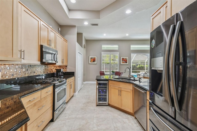 kitchen featuring a sink, stainless steel appliances, beverage cooler, and light brown cabinets