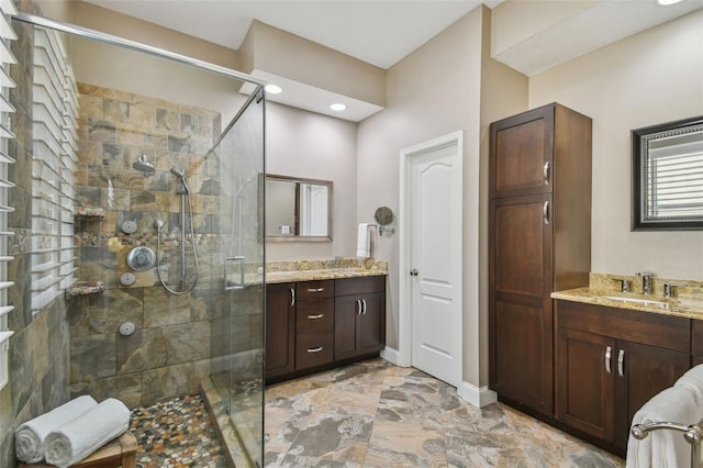 full bath featuring a shower stall, vanity, and baseboards