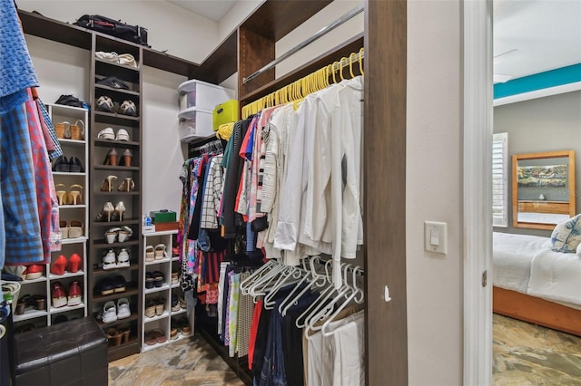 walk in closet with stone finish floor