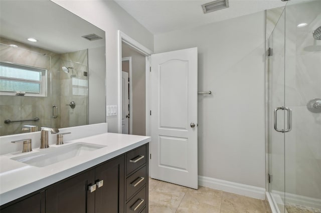 bathroom with visible vents, a shower stall, vanity, and baseboards