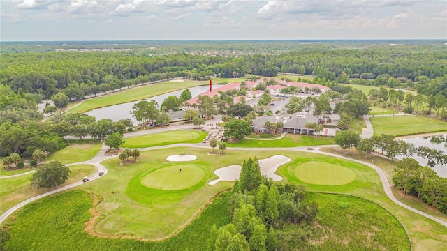 birds eye view of property with a view of trees, view of golf course, and a water view